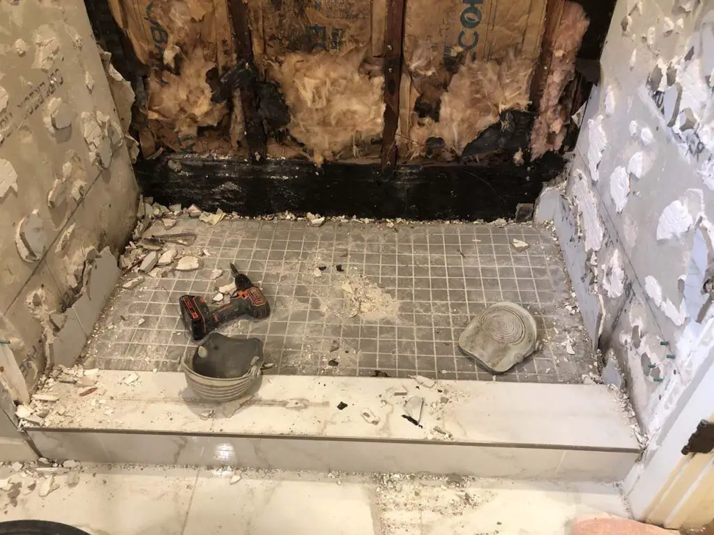 Looking at the shower floor during demo, where you can see the hot-mopped floor, but the general contractor did not employ a membrane