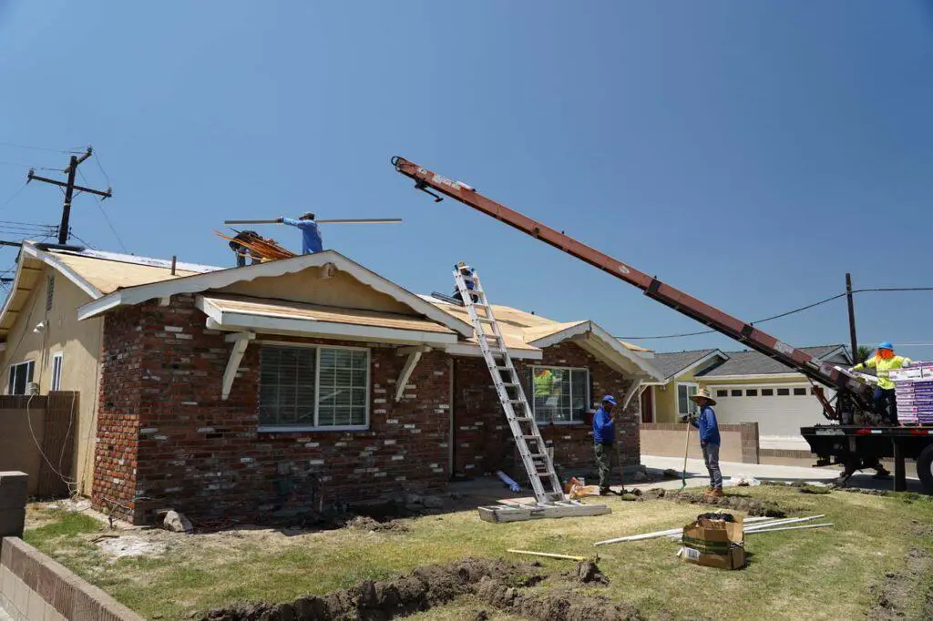 The distributor for the roofing company putting the roofing materials onto the roof of the rental house