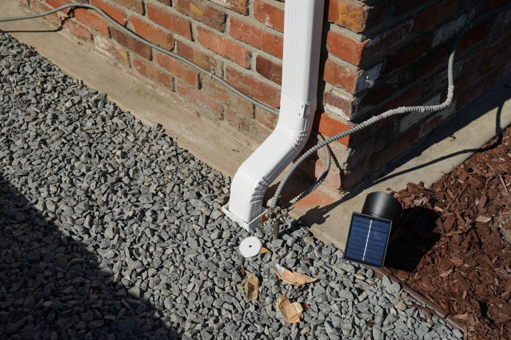 An example of a downspout fed by storm gutters going right into a drain that quickly moves water away from the house and towards the street