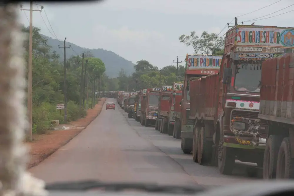 A massive line of trucks hauling coal or other mining goods waiting to be transported by ship